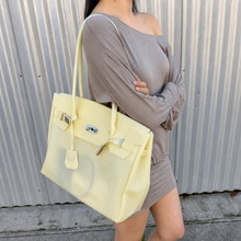 Yellow Sencieres jelly Firkin bag, glossy translucent TPU handbag — held in hand
