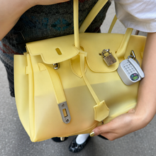 Yellow Sencieres jelly Firkin bag, glossy translucent TPU handbag — angled side view