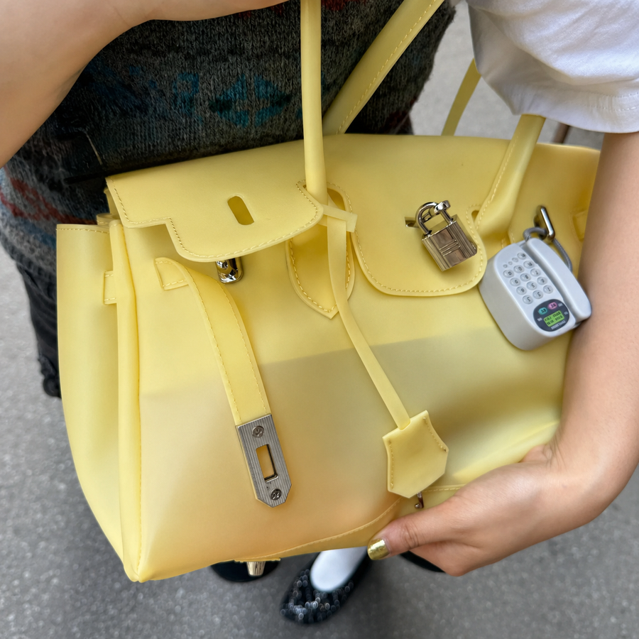 Yellow Sencieres jelly Firkin bag, glossy translucent TPU handbag — angled side view
