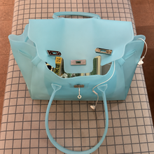 Sky-Blue Sencieres jelly Firkin bag, glossy translucent TPU handbag — held in hand